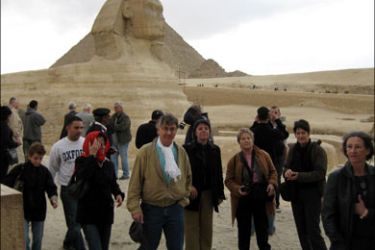 afp : Foreign tourists walk past the Sphinx at the site of the Great Pyramids of Giza, south of Cairo, on February 23, 2009. Egyptian police said they have arrested three suspects