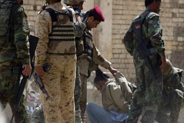 afp/ Members of the Iraqi army intelligence unit detain an alledged sniper from the Sahwa militia in Baghdad's Fadel district on March 29, 2009.