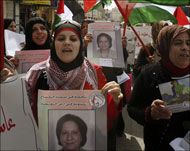 سيدات فلسطينيات يشاركن في مسيرة بيوم المرأة العالمي في مدينة الخليل (رويترز)