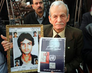 والد المفقود جمال معروف يحمل صورا لابنه (الجزيرة نت)