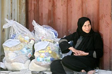 AFP - A Palestinian woman sits next to a bag of aid food she received from the United Nations Relief and Works Agency (UNRWA) at the refugee camp of Rafah in the southern Gaza Strip on April 28, 2009. US President Barack Obama's administration has asked Congress to allow continued aid to