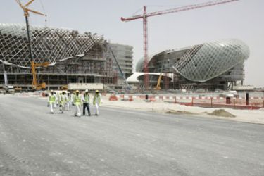 Construction workers leave the site of the Yas Hotel, which will be the flagship project and main feature of the Yas Marina Formula One race circuit in Abu Dhabi