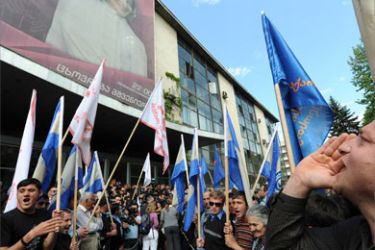 Georgian opposition supporters shout during a rally outside Georgia's state run Channel One television offices in Tbilisi on May 14, 2009