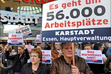 afp : Employees of German retailer Karstadt demonstrate with posters, one reading "It's a question of 56,000 jobs" (R) as they protest in front of a Karstadt department store in