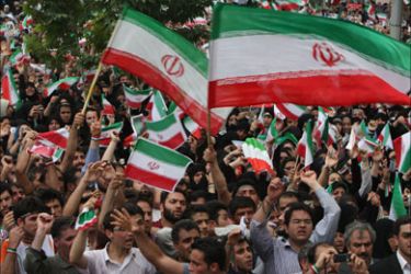Supporters of Iranian President Mahmoud Ahmadinejad wave national flags during an election campaign rally in Tehran on June 10, 2009