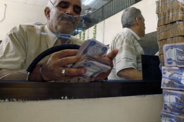 A client counts his money at Al-Rafidain bank in BaghdadJune 21, 2009. Total bank deposits in February -- the latest figures available -- jumped by half to 36.6 trillion
