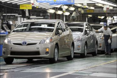 afp : Toyota Motors Tsutsumi factory workers check the latest assembled Prius hybrid vehicle at the factory in Toyota city, Aichi prefecture, on June 35 2009. Toyota's latest