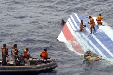 r : Brazilian Navy sailors pick a piece of debris from Air France flight AF447 out of the Atlantic Ocean, some 745 miles (1,200 km) northeast of Recife, in this handout photo