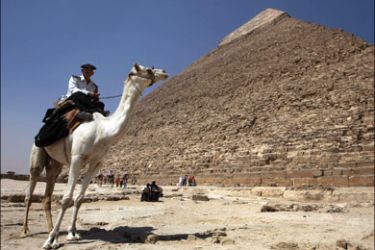 afp : A camel-mounted policeman surveys the grounds of the Cheops pyramids in the Giza plateau in the outskirts of Cairo where security is heightened on June 2, 2009, in preparation