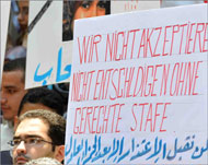 متظاهرون حملوا لافتاتباللغتين العربية والألمانية (الجزيرة نت)