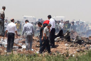 Iranians gather near the debris of the Caspian Airlines plane which crashed into a farmland near the city of Qazvin, northwest of Tehran, on July 15, 2009. The Iranian airliner