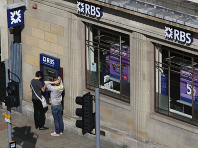 A customer uses a Royal Bank of Scotland (RBS) cash machine in Edinburgh, Scotland August 7, 2009. Royal Bank of Scotland reported more losses on Friday as investment