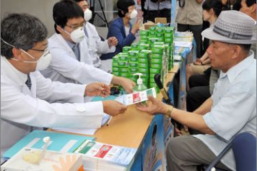 South Korean doctors give swine flu advice to citizens outside the City Hall in Seoul on August 27, 2009 as part of the government's campaign to stem the spread of the influenza A (H1N1) virus.
