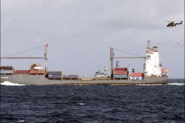 r : An EU NAVFOR ship (back) convoys the released German-flagged container vessel Hansa Stavanger in the Gulf of Aden August 4, 2009. Somali pirates holding a
