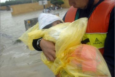 A man holds a baby as a family is rescued from flooding brought by Typhoon Morakot in Chiatung, Pingtung county, in southern Taiwan, on August 9, 2009