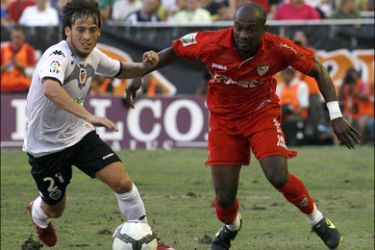 r : Valencia's David Silva (L) and Sevilla's Ndri Romaric fight for the ball during their Spanish first division soccer match at the Mestalla Stadium in Valencia August 30, 2009.