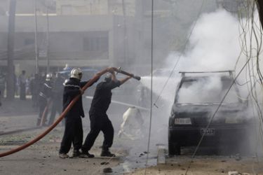 Firemen put out a fire in a burning vehicle after a bomb attack in Karrada District, central Baghdad August 16, 2009. Two people were wounded in the attack, according to police.