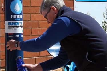A resident fills a reusable plastic bottle from a new public drinking fountain on the first day of a bottled water ban in the Southern Highlands community of Bundanoon