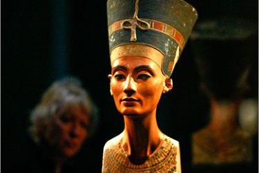 A woman looks at the statue of Nefertiti (Nofretete) during a press preview at the 'Neues Museum' (New Museum) building in Berlin October 15, 2009. The famous bust which is part of a permanent Egyptian exhibition and papyrus