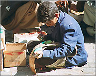 طفل يمني يعمل في تلوين حزام الجنبية (الجزيرة نت)