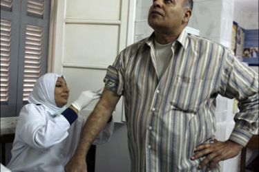 r : A nurse vaccinates a would-be pilgrim against H1N1 in a health centre in Cairo, November 8, 2009, ahead of the annual pilgrimage to Mecca. Egypt received the second