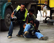 الصحفي عبد الرحيم القوصيني سقط أرضا بعد أن أصيب جراء المواجهات مع الاحتلال (الجزيرة)