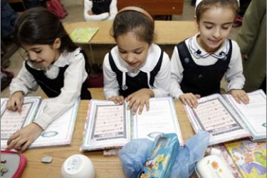 Iraqi schoolgirls read Koranic verses during religion class at the Zuhur elementary school in Baghdad on November 17, 2009