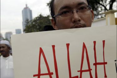 epa : epa01982966 A Malaysian muslims hold a placard reading 'There is no other Allah than Allah, there is only one god" as he takes part in a protest against a court ruling
