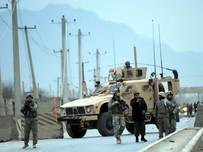 NATO and US soldiers stand guard at the site of a suicide attack near Camp Phoenix in Kabul on January 26, 2010. A suicide bomber in a car laden with explosives struck near a US military base in Kabul on January 26, injuring at least nine Afghan civilians, police and the NATO-led force said.