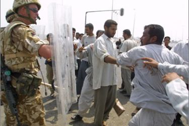 (FILES) A file photo taken on August 9, 2003, shows Iraqi civilians clashing with British soldiers in Basra, Iraq.