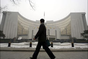 r : A man walks past the headquarters of the central bank of the People's Republic of China in Beijing, January 19, 2010. China still needs to stick to its "moderately loose" monetary