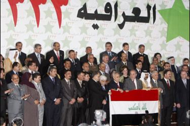 F/Iraq's former pro-west Prime Minister Iyad Allawi (6th R) holds the Iraqi flag along side Sunni Muslim Vice President Tareq al-Hashemi (7th R) during the unveiling of the 'al-Iraqiya Alliance' party in Baghdad on January 16, 2010.