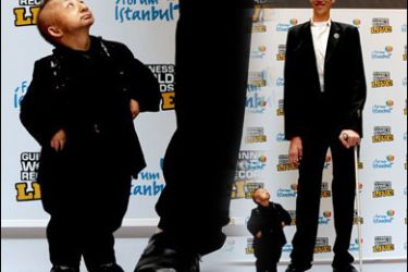F/The shortest man in the world He Pingping (L), standing at 2 ft 5.37 in (74.61 cm), holds onto the finger of the world’s tallest man, Sultan Kِsen (up), who is 8 ft 1 in (246.5 cm) tall, during the launch of the Guinness World Records live roadshow in Istanbul, on January 14, 2010. AFP PHOTO / MUSTAFA OZER