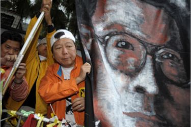 Pro-democracy demonstators carry a portrait of mainland dissident Liu Xiaobo as they down a street in Hong Kong on January 1, 2010 calling for universal sufferage and the release of political prisoners