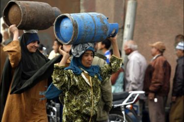 r : Women carry gas canisters in front of a gas canister warehouse in Cairo February 4, 2010, as some areas of the country face a gas canister shortage. REUTERS/Asmaa
