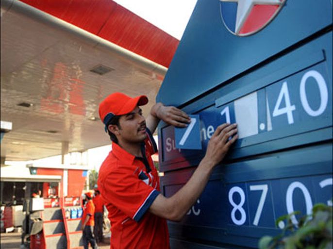 afp : A Pakistani gas station employee adjusts a price board showing the newly fixed fuel prices in Karachi on February 1, 2010. The Oil and Gas Regulatory Authority (OGRA) has