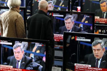 r : Britain's Prime Minister Gordon Brown is seen on television screens in an electrical store in Edinburgh, Scotland, as he gives evidence to the Iraq Inquiry being held