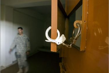 A U.S. Army soldier with 508th Special Troops Battalion, 82nd Airborne Division, walks inside a cell for detainees at a local police station outside the town of Kandahar, southern Afghanistan