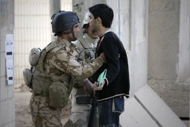 An Iraqi soldier frisks a man at the entrance to a polling centre in central Baghdad on March 7, 2010