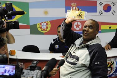 A man shows to the media the official 2010 FIFA World Cup ticket he just purchased on April 15, 2010 at the Maponya shopping mall in Soweto on the first day of the opening