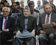 كرزاي (وسط) أثناء زيارته مقر اللجنة المستقلة للانتخابات في كابل (الفرنسية)