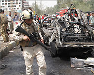 رجل أمن عراقي يعاين سيارة دمرت أمام سفارة إيران (الفرنسية)