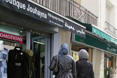 Two veiled women are about to enter a shop selling clothes for muslim women in Paris, on April 21, 2010. French National Assembly is to debate