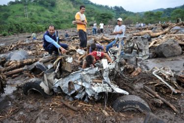 F/People watch a car destroyed by a mudslide caused by tropical storm Agatha on May 30, 2010, in the municipality of Palin, Escuintla, 36 km south of Guatemala City. The first tropical storm of the season has left at least 18 people dead in Guatemala and El Salvador,