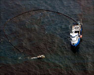 قارب يحاول احتواء بقعة من النفط المتسرب من البئر المنفجرة في خليج المكسيك (رويترز) 