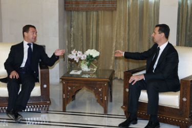 Syrian President Bashar al-Assad (R) speaks with his Russian counterpart Dmitry Medvedev (L) at Al-Shaab presidential palace in Damascus