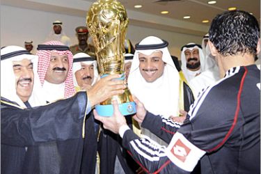 REUTERS/ Kuwait's Prime Minister Sheikh Nasser al-Mohammad al-Sabah (L) hands the Crown Prince trophy to Al Kuwait's Khaled Al-Fadhly (R) during the Crown Prince Cup final