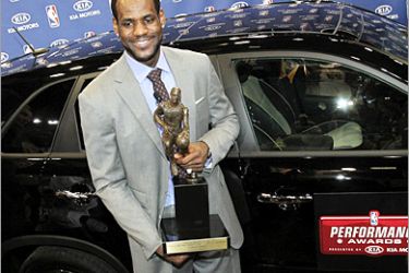 REUTERS/ LeBron James of the Cleveland Cavaliers poses in front of a 2011 Kia Sorento car with the NBA's Most Valuable Trophy after a ceremony to present him with the award at the