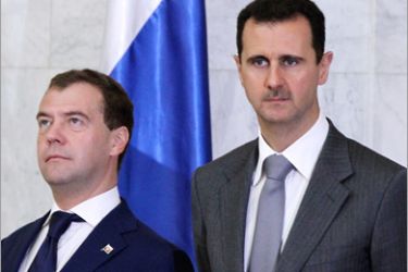 AFP - Russian President Dmitry Medvedev (L) stands next to his Syrian counterpart Bashar al-Assad before the start of their joint press conference after their meeting at Al-Shaab