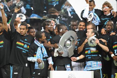 f_Om's players hold the L1 French football league trophy on May 15, 2010 during a parade in front of supporters after the club won the French L1 football match Marseille vs. Grenoble at the